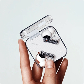 A hand holding an open, transparent square case containing white wireless earbuds.